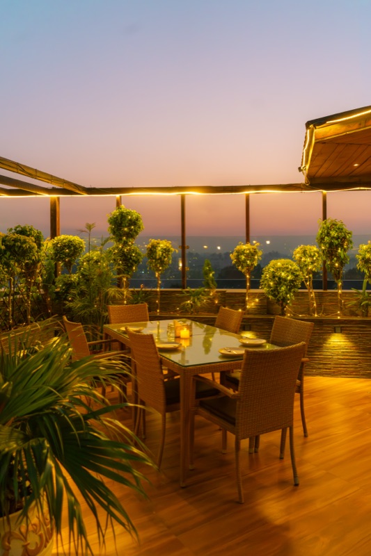 The hotel’s rooftop terrace at sunset, a table laid under string lights
