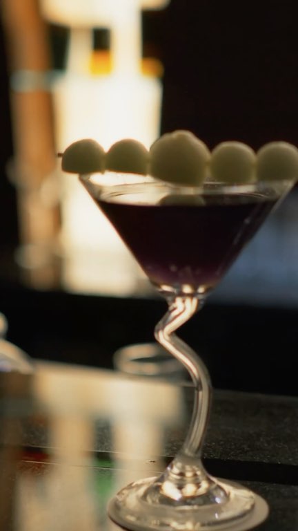 Reel: blue flames run along the bar around a dark cocktail