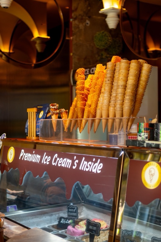 The Bell&rsquo;s counter at night: a tall cone display under warm wall lamps