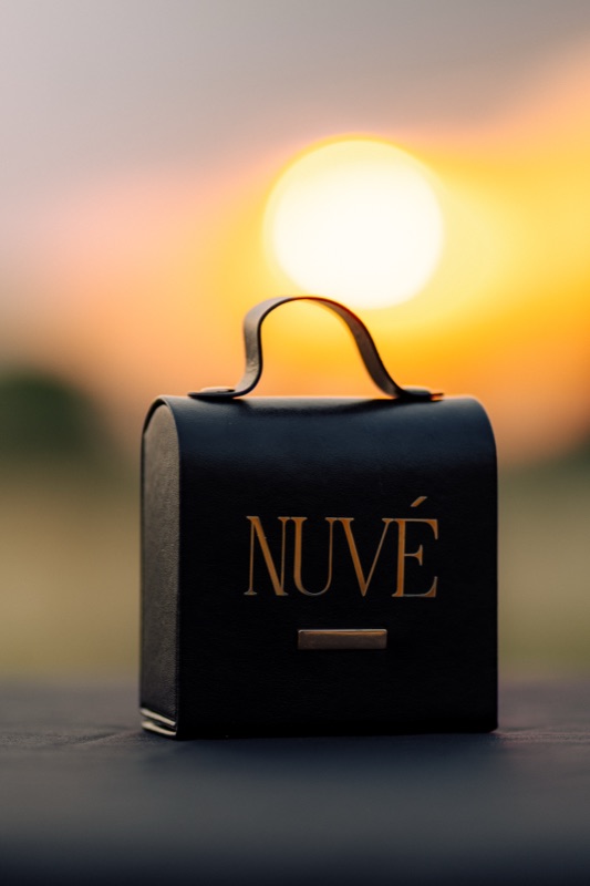 The black Nuve gift box on a ledge, the sun setting behind it
