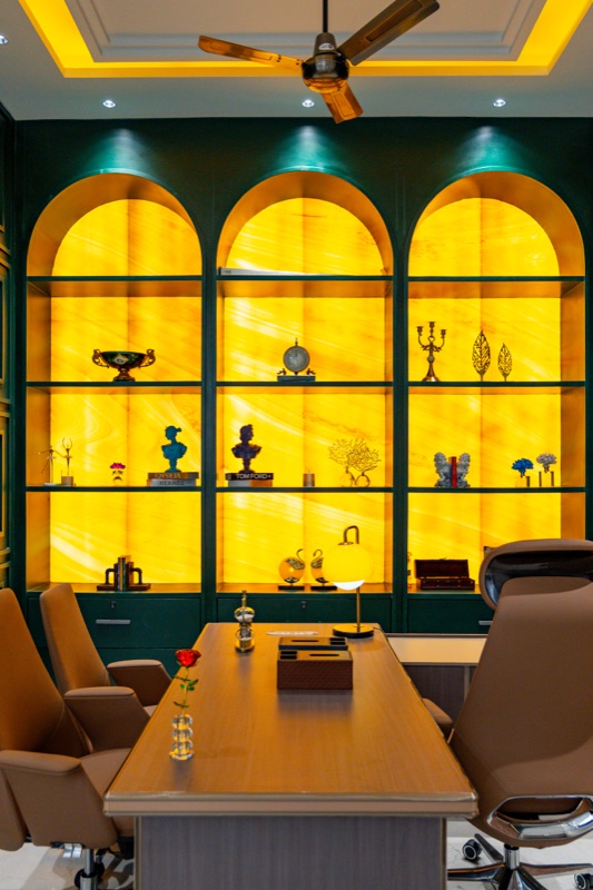 A meeting room with three backlit yellow arched niches behind a long wooden table