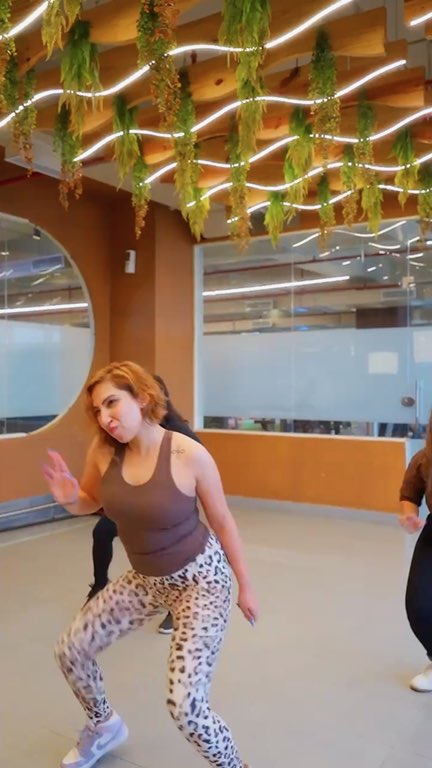 Reel: a dance class under a wavy wooden ceiling hung with plants